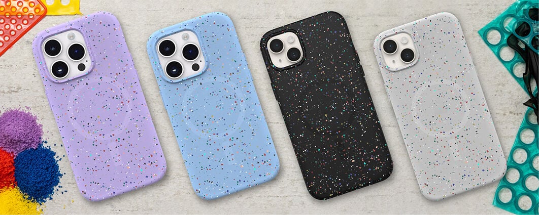 Four speckled phone cases in purple, blue, black, and gray on a textured surface.