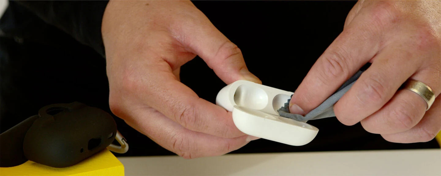 Close-up of hands using a tool on a white object against a black background