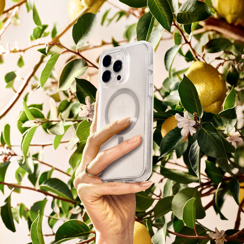 Hand holding a phone case with a lemon tree in the background