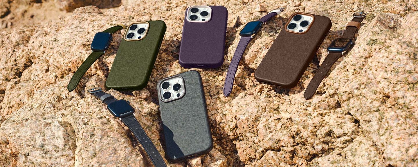 Five phone cases with straps on a textured stone surface
