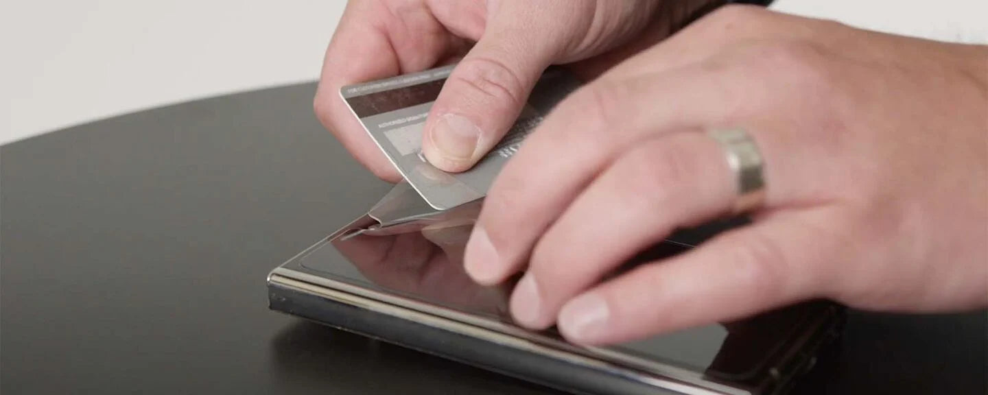 Person using a stylus on a digital device with a neutral background