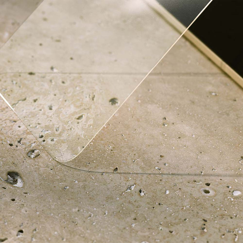 Close-up of a textured concrete surface with a clear plastic sheet overlay.